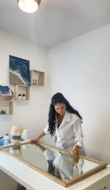 Amanda Berton travaillant sur un cadre miroir dans son atelier à Genève