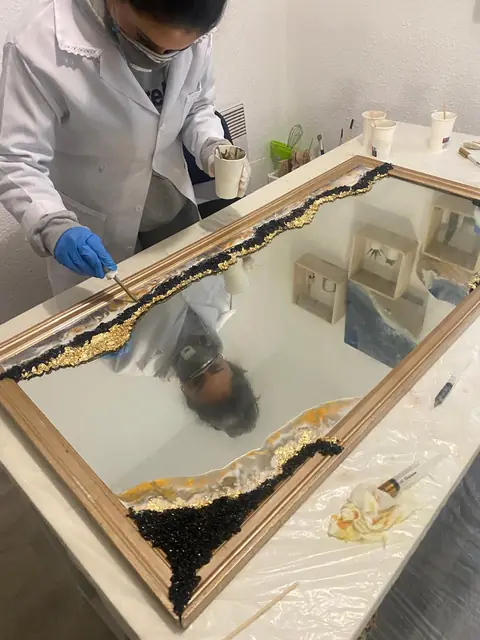 Application de feuille d'or sur un cadre miroir à l'atelier