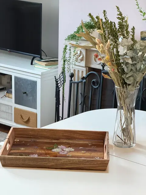 Plateau long en bois clair avec poignées ouvertes et fleurs pressées pastel dans la résine