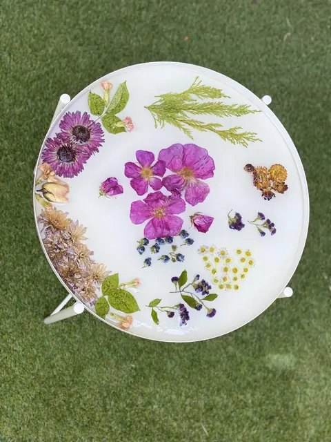 Table basse blanche avec fleurs pressées dans la résine, vue de dessus